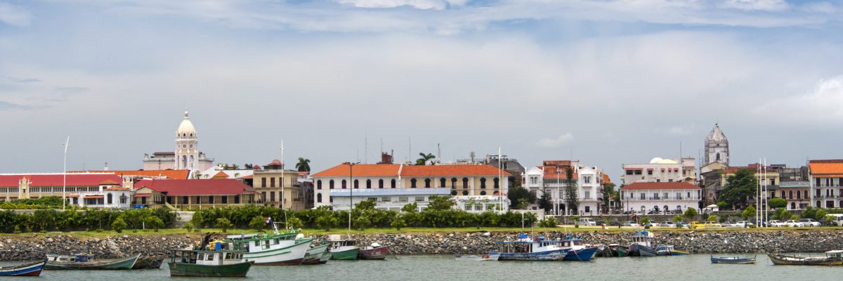 Skyline of Panama city Casco Viejo: the historic old town. The skyline is seen over water with some small fishing boats floating.